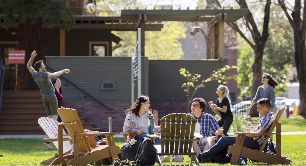 students relax outside on the lawn on the Sacramento campus